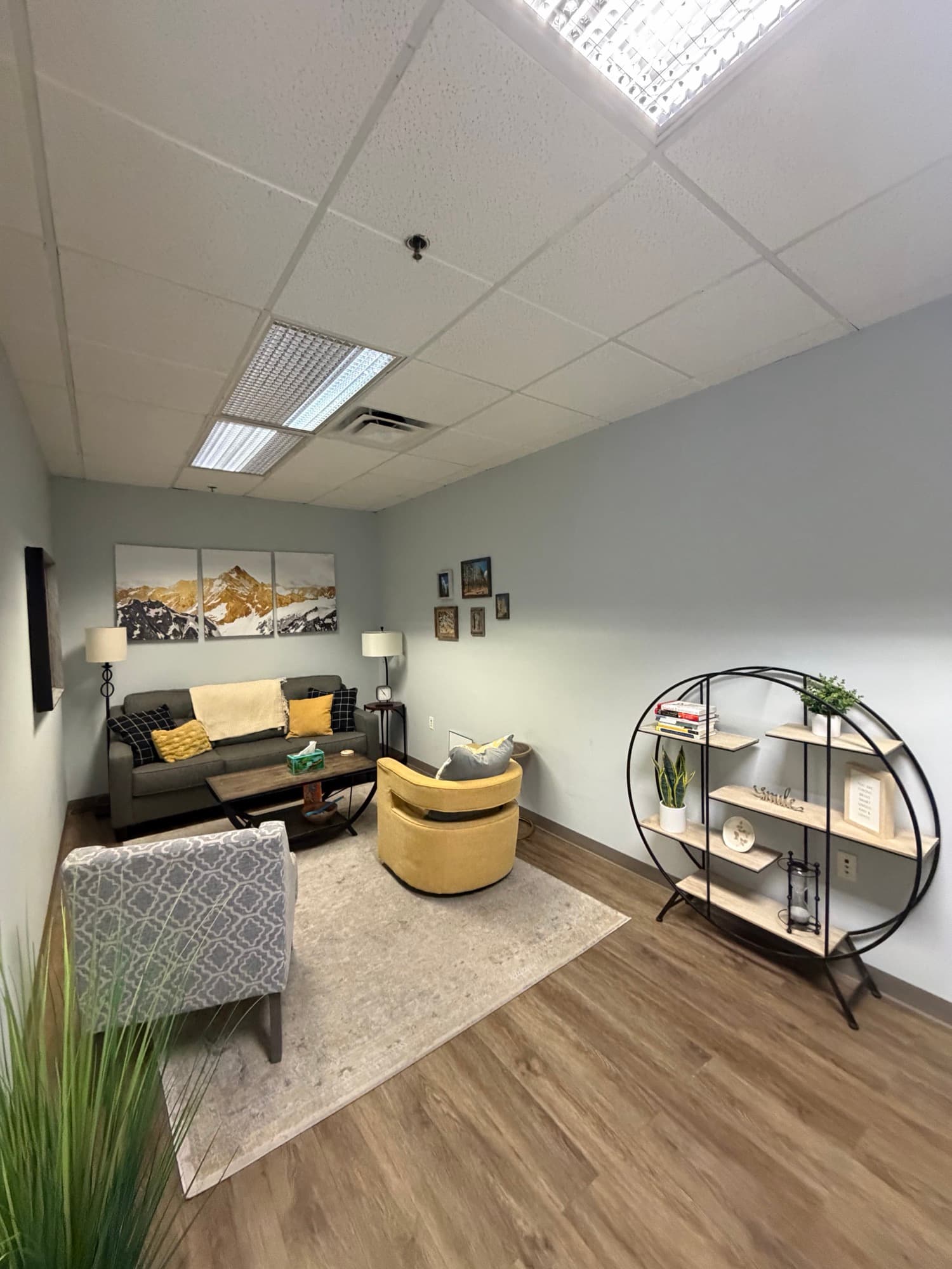 Therapy room with a Joshua Tree triptych and mustard accent chair