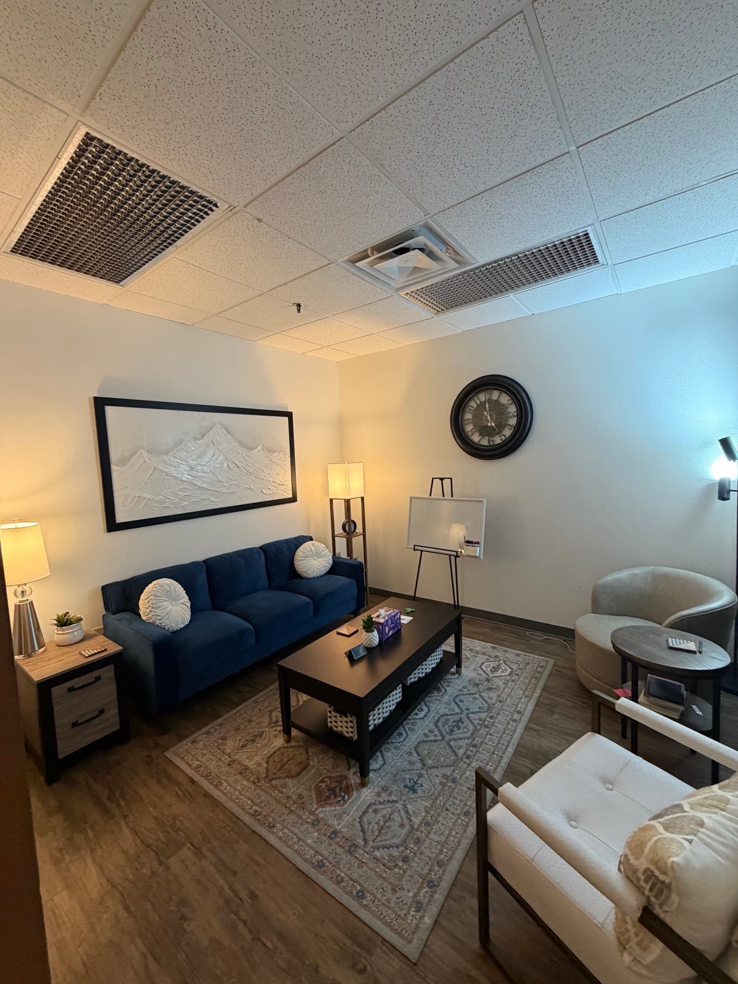 Therapy room with a mountain landscape painting and blue sofa